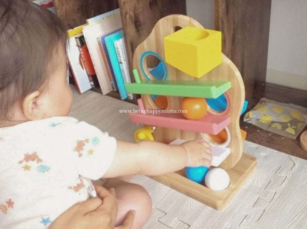 Baby tracking the ball on the slope toy.