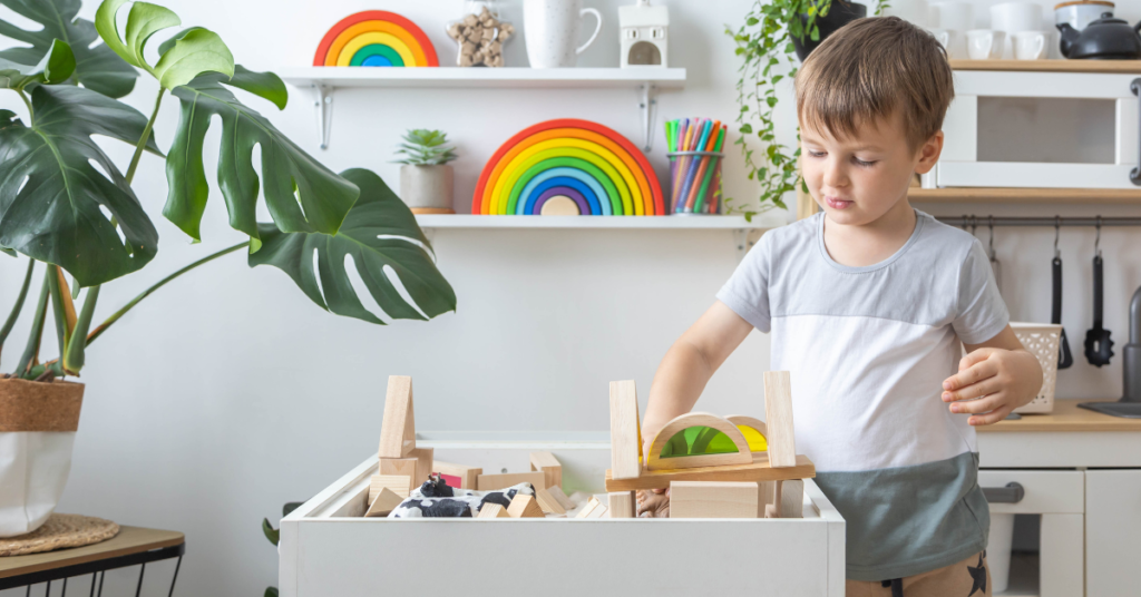 A child is playing blocks on a desk.